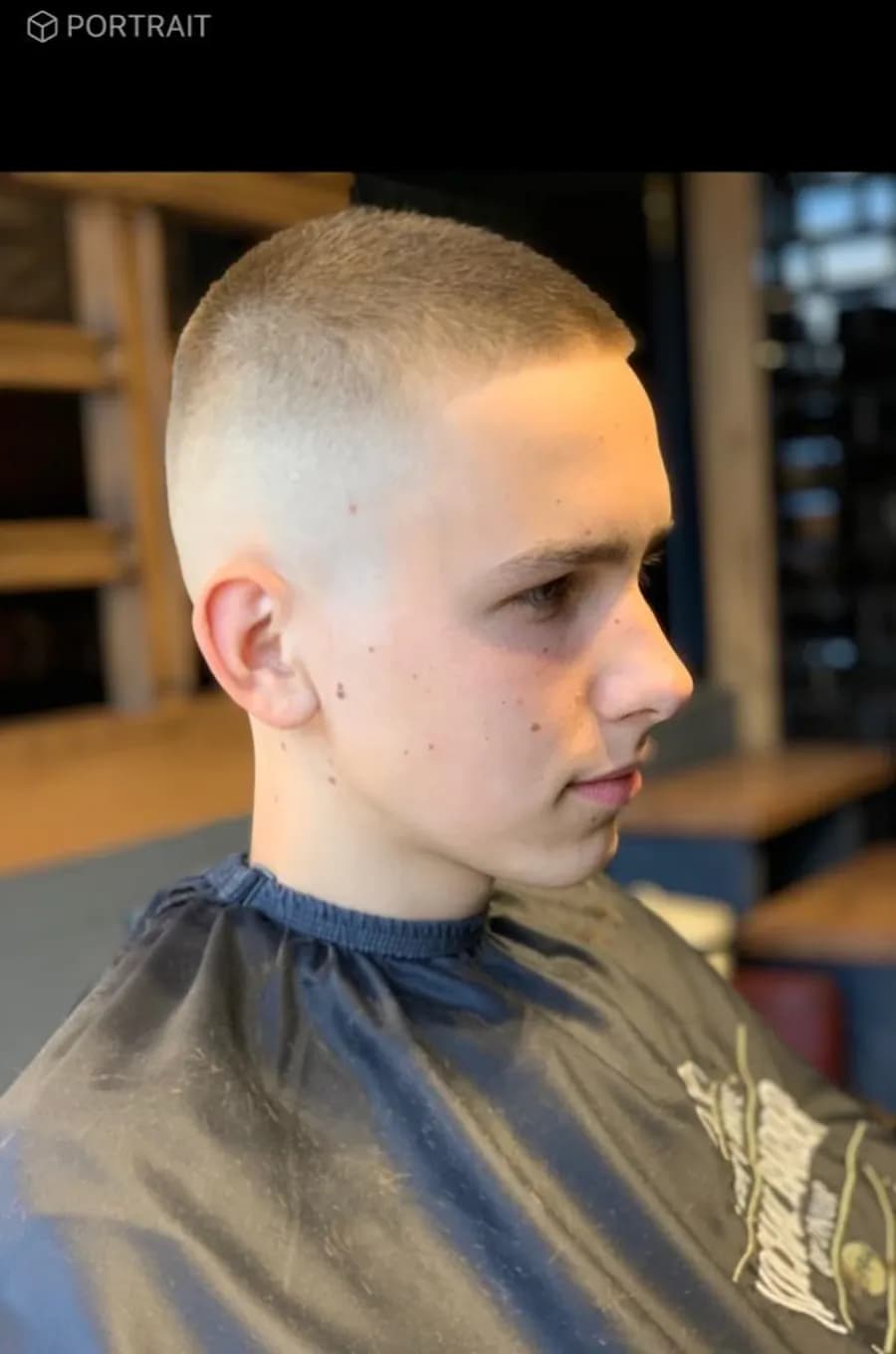 A high skin fade in profile, blended into a short crop on top