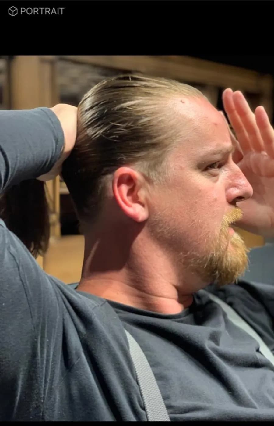 A long scissor cut being combed straight back at the chair